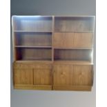 A continental two section storage unit comprising of a sliding door cabinet base and bookcase above,