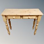A pine side table fitted with two drawers,