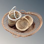 A large wicker twin handled crib/basket together with two further wicker shopping baskets