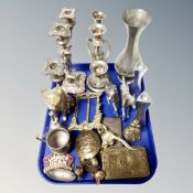 A tray containing assorted metal wares including table candelabra, horse figures, belt buckles,