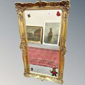 A mirror in ornate gilt frame, 54cm by 93cm.