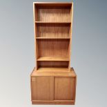 A 20th century Scandinavian teak sliding double door low cupboard together with similar open