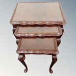 A nest of three mahogany and beech glass topped tables.
