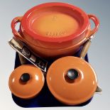 An enamelled cast iron Doufeu Dutch Oven together with two Le Creuset lidded saucepans.