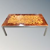 A 20th century Danish glass topped coffee table on metal legs.