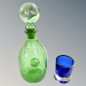 A vintage green glass decanter and a beaker.