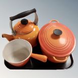 A Le Creuset cast iron lidded casserole pan together with a Le Creuset kettle and sauce basin.