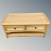 A contemporary oak two tier coffee table fitted with two drawers.