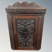 A 19th century heavily carved oak hanging corner cabinet.