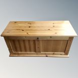 A contemporary pine blanket box with key.