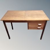 A mid-20th century teak writing desk fitted with two drawers on raised legs.