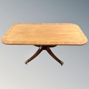 A reproduction mahogany rectangular pedestal coffee table with brass capped feet.