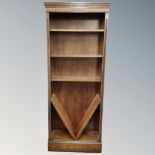 A set of contemporary open bookshelves in an oak finish.