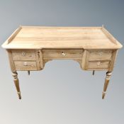 A 19th century pine five drawer writing desk on raised legs with gallery.
