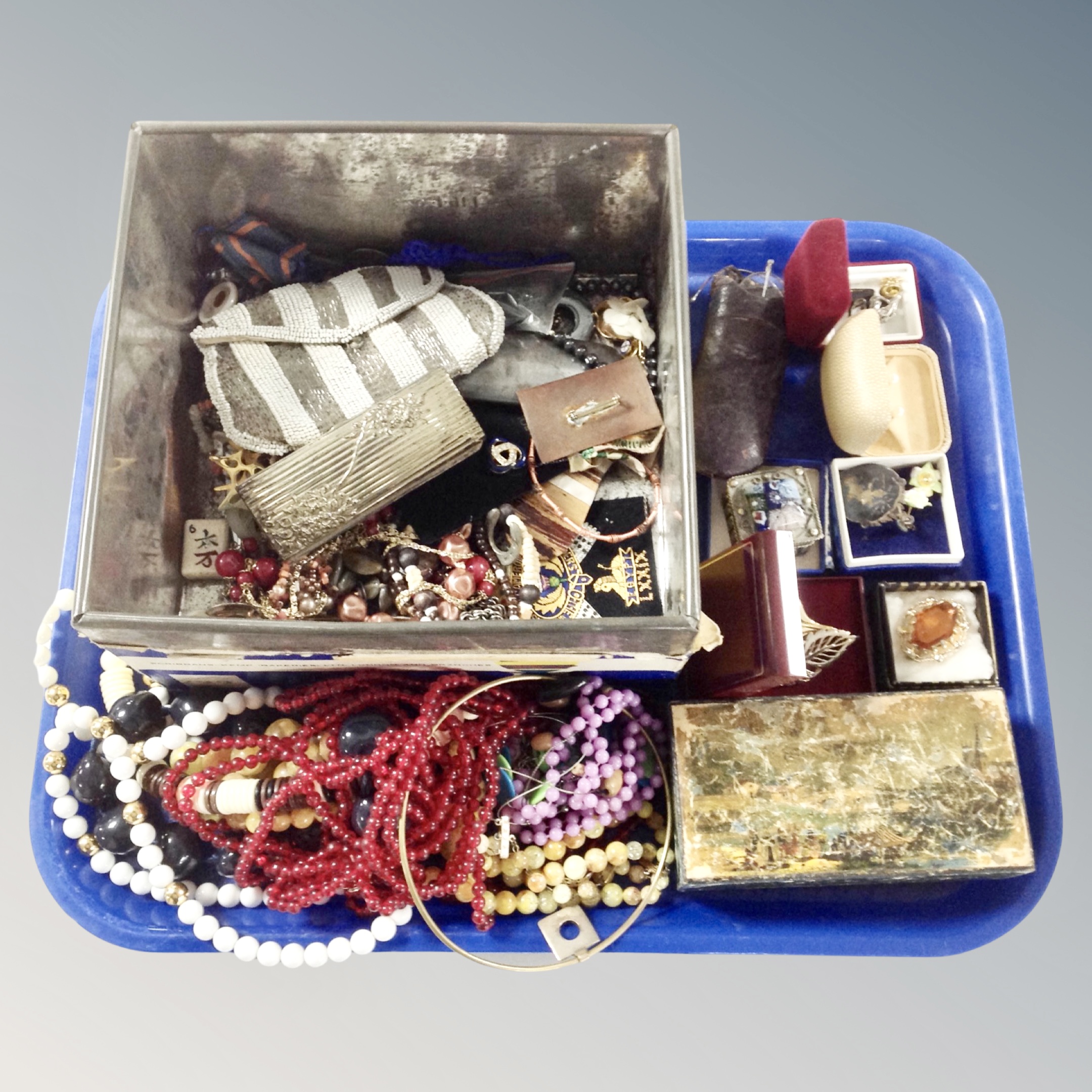 A tray of costume jewellery, a tin of beads, spectacles, brooches etc.