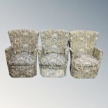 A set of three 20th century wingback bedroom chairs upholstered in a tapestry fabric.