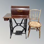 A vintage Singer treadle sewing machine (locked), together with a beech wood kitchen chair.