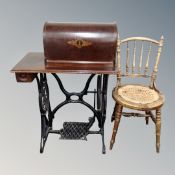 A vintage Singer treadle sewing machine (locked), together with a beech wood kitchen chair.