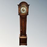 A 20th century oak granddaughter clock with brass dial.