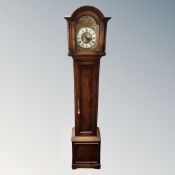 A 20th century oak granddaughter clock with brass dial.