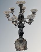 A cast iron floor-standing seven way candelabrum on cherub support.