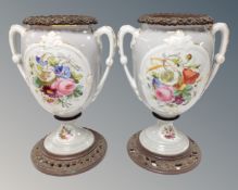 A pair of twin handled Victorian transfer printed vases on metal bases with liners