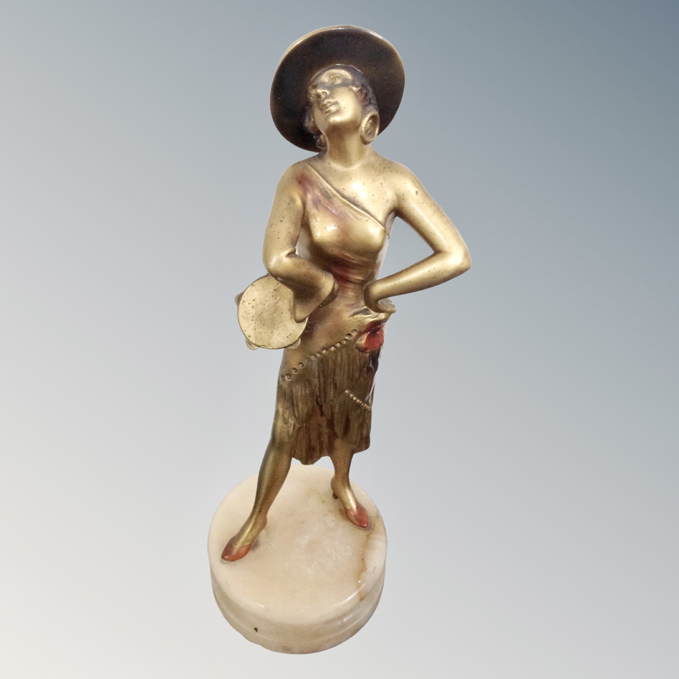 An Art Deco painted spelter figure on marble socle.