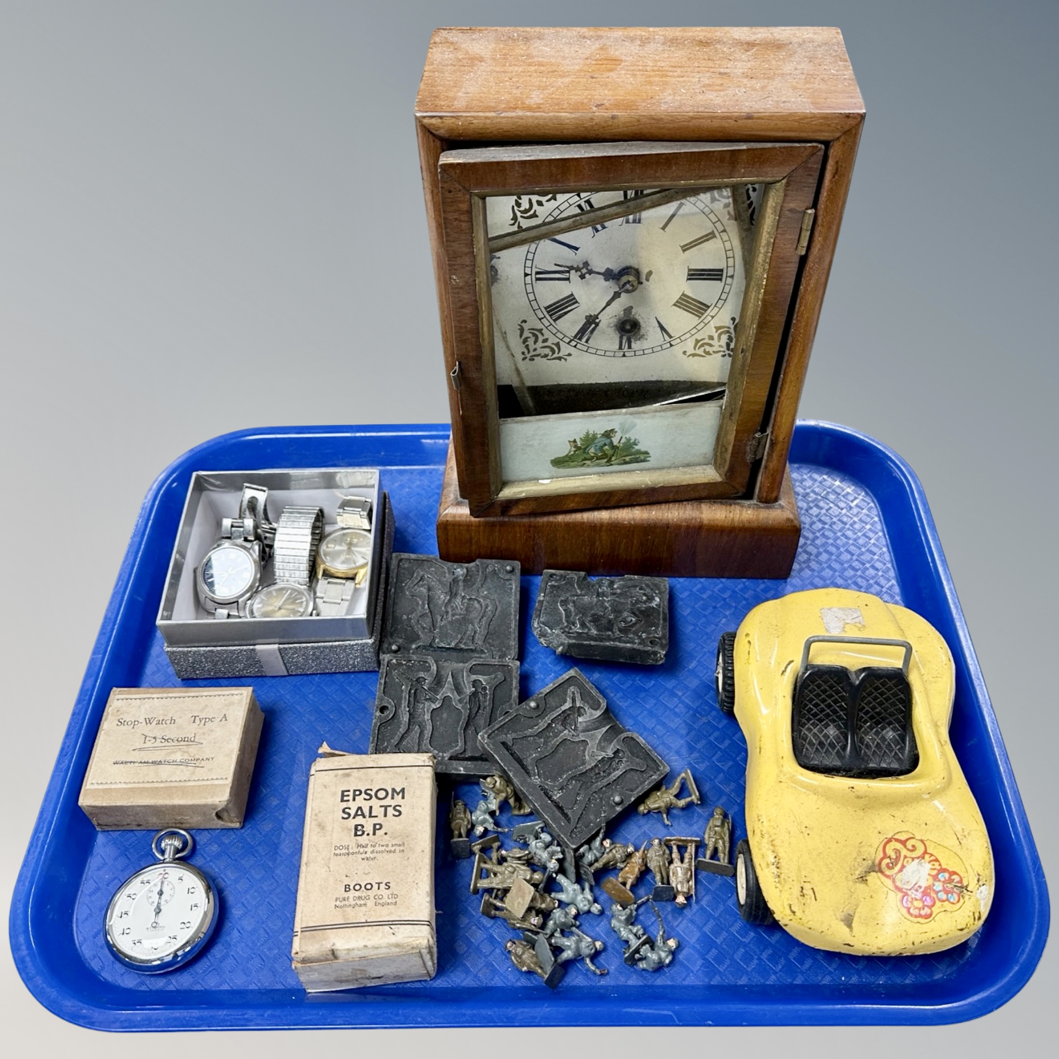 A tray containing an antique mantel clock, metal figures, chrome plated stopwatch,