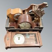 A box containing two wall clocks and a quantity of clock parts.