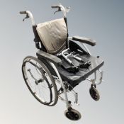 A Karma folding lightweight wheelchair with cushion and footrests.