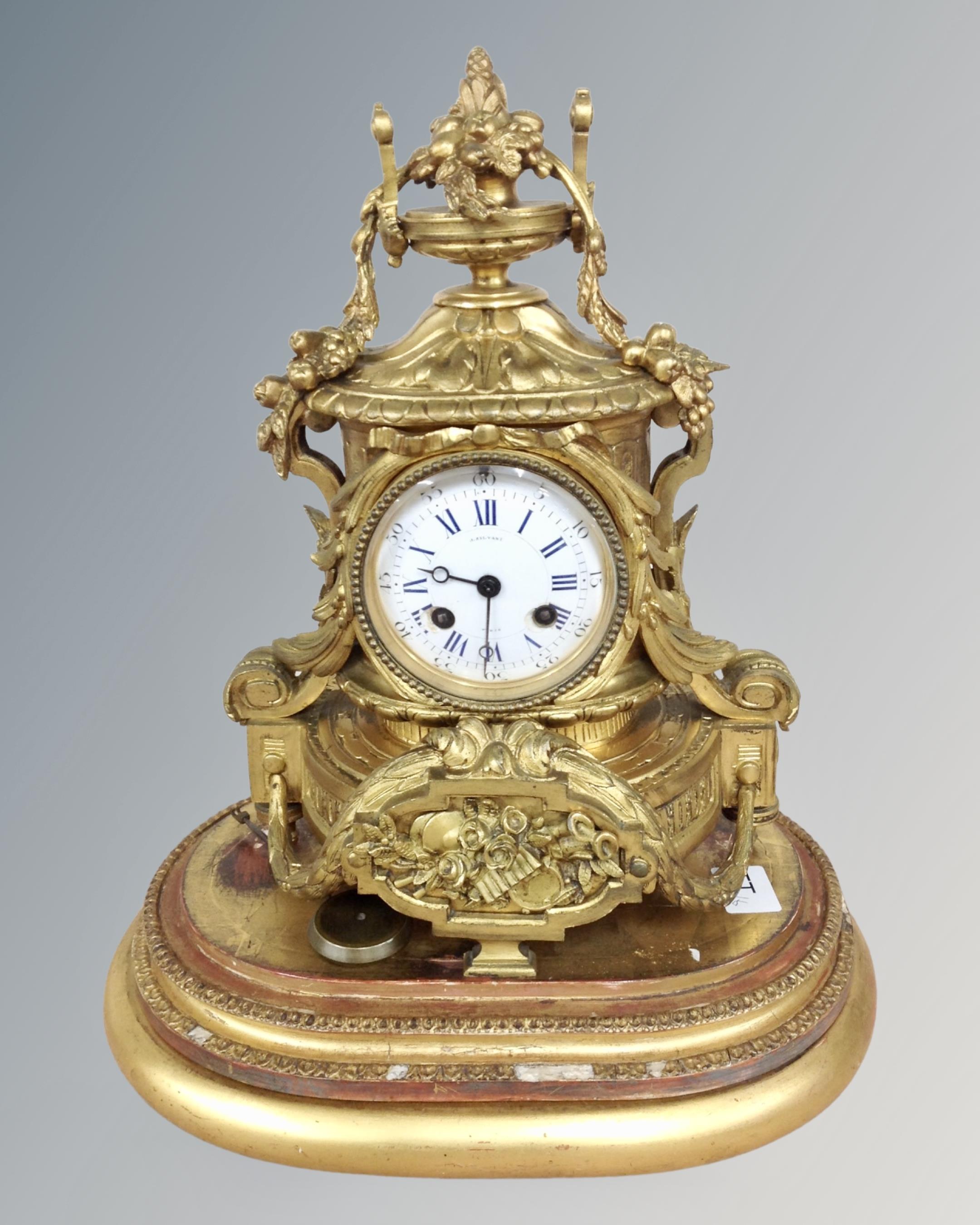 A 19th century French gilt metal mantel clock with enamelled dial, retailed by J.