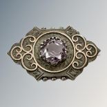 A Victorian white metal brooch with yellow metal overlay set with facet cut central amethyst.