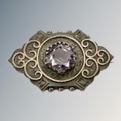 A Victorian white metal brooch with yellow metal overlay set with facet cut central amethyst.