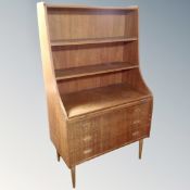 A mid-20th century Danish set of teak bookshelves fitted with three drawers beneath on raised legs.