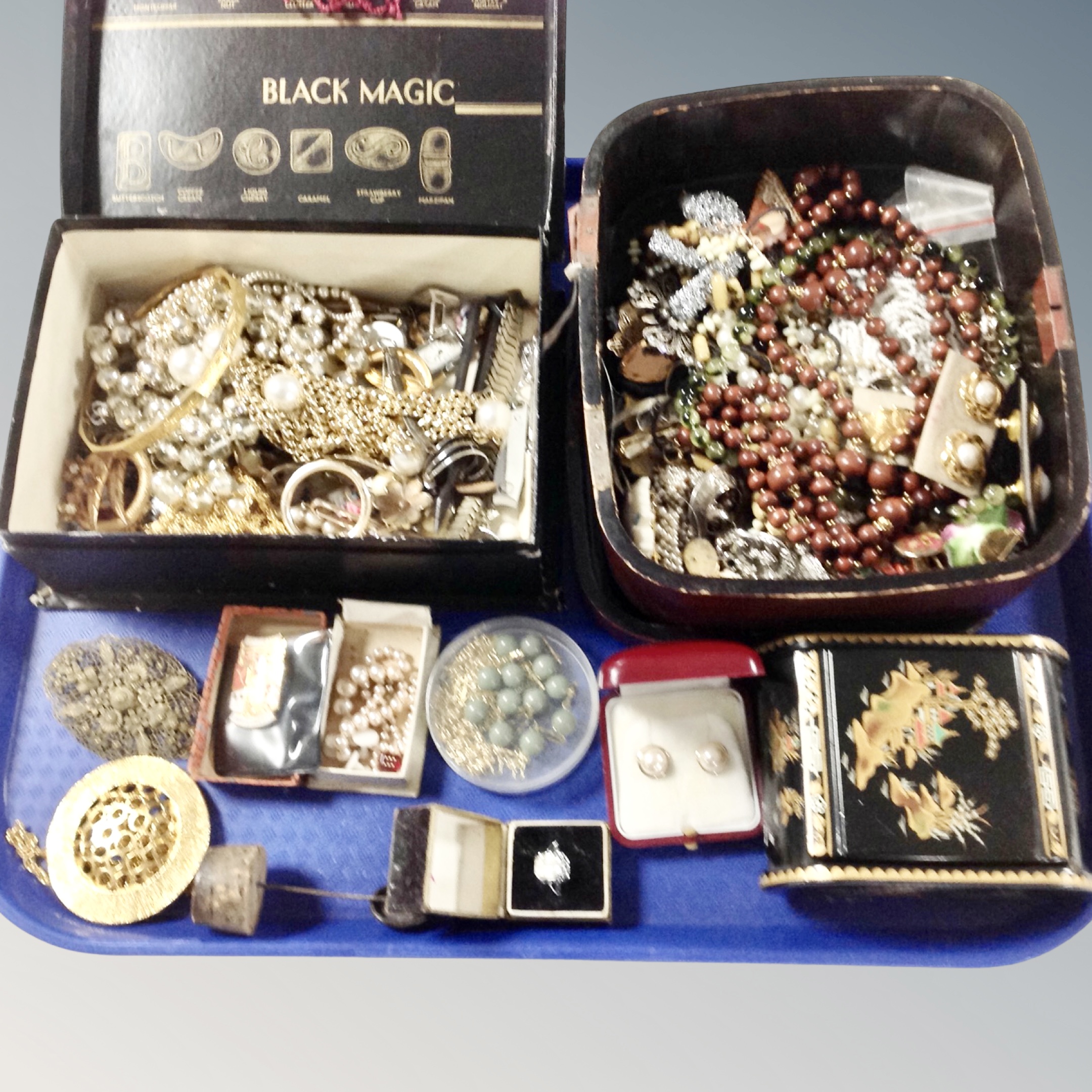 A quantity of costume jewellery, a lacquered box containing necklaces, brooches, dress rings etc.