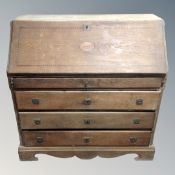 A 19th century inlaid oak secretaire bureau fitted with four drawers beneath on bracket feet.