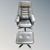 A Scandinavian style black leather swivel armchair with footstool.