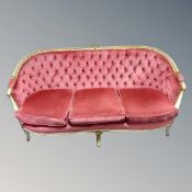A continental carved beech framed salon settee upholstered in a pink buttoned dralon.