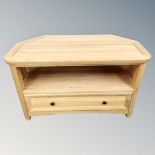 A contemporary oak corner TV stand fitted with a drawer.