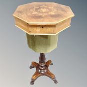 A 19th century inlaid mahogany and rosewood pedestal work table on paw feet.