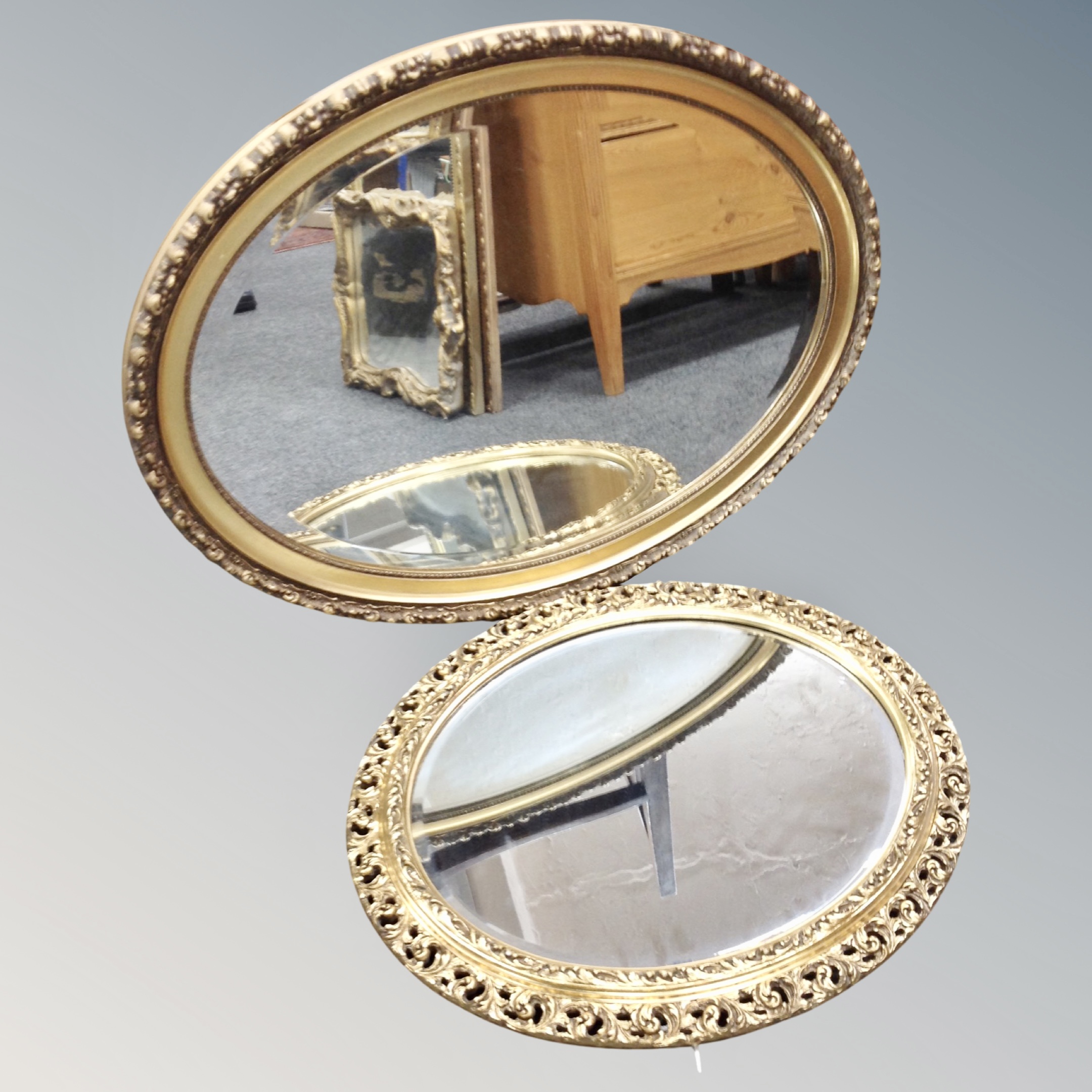An oval bevel edged mirror in gilt frame together with a further oval framed mirror.