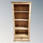 A set of pine open bookshelves fitted with a drawer beneath.