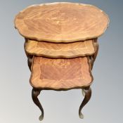 A nest of three shaped Italian style occasional tables.