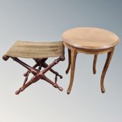 A carved beech wood circular occasional table together with a folding X-frame stool.