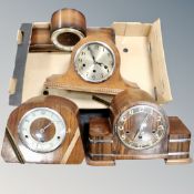 A box containing four early 20th century mantel clocks.