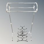 A chrome metal towel rail together with a small wine bottle rack.