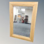 A light oak framed mirror.