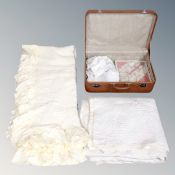 A vintage luggage case containing table linens together with a hand stitched Durham quilt and bed