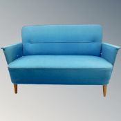 A 20th century Danish low backed settee in turquoise fabric