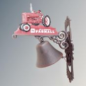 A cast iron bell on McCormick Farmall tractor wall bracket.